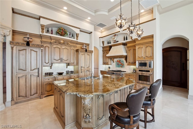 kitchen featuring custom exhaust hood, a breakfast bar, backsplash, appliances with stainless steel finishes, and an island with sink