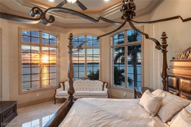 bedroom with a tray ceiling, tile floors, ceiling fan, and a water view