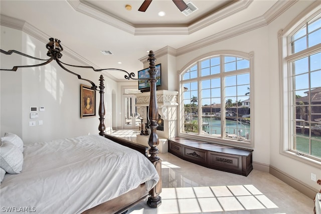 bedroom with a water view, a raised ceiling, ceiling fan, and crown molding