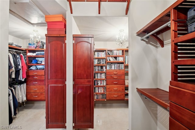 walk in closet featuring a notable chandelier and light tile floors