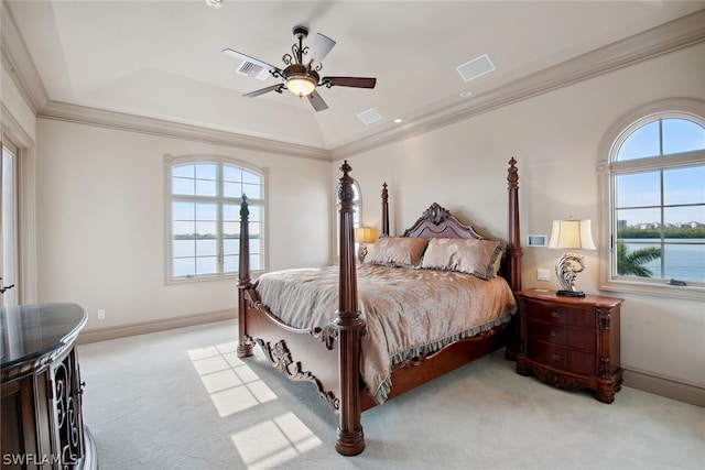 carpeted bedroom featuring ornamental molding, ceiling fan, a water view, and a raised ceiling