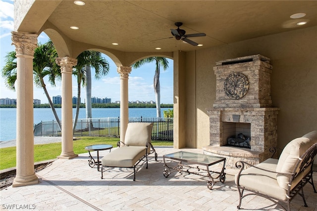 view of patio / terrace with ceiling fan and a water view