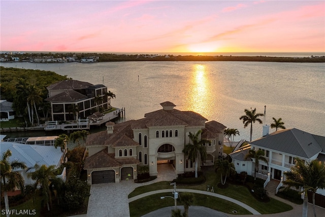 aerial view at dusk featuring a water view