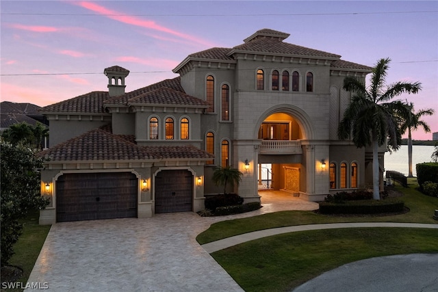 mediterranean / spanish-style home featuring a garage and a yard