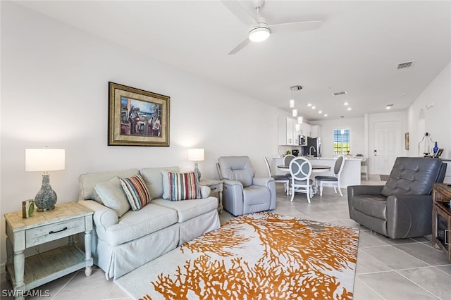 living area featuring ceiling fan, light tile patterned flooring, and visible vents