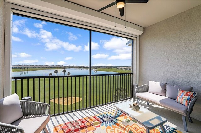 sunroom / solarium with ceiling fan and a water view