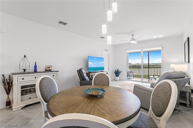 dining room with light tile patterned floors, visible vents, and a ceiling fan