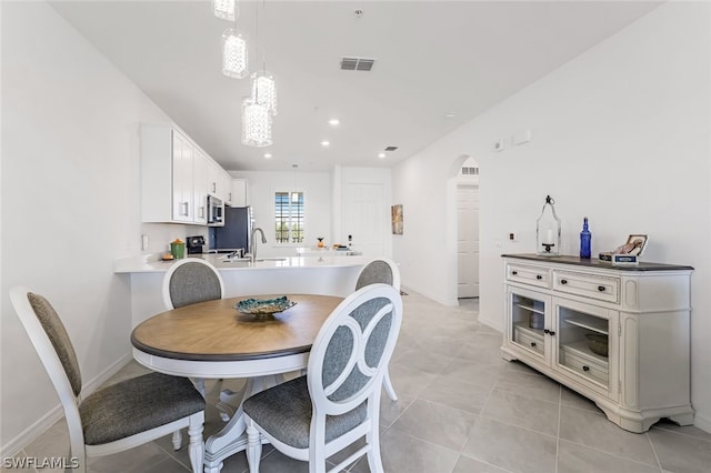 dining area featuring recessed lighting, baseboards, visible vents, arched walkways, and light tile patterned flooring