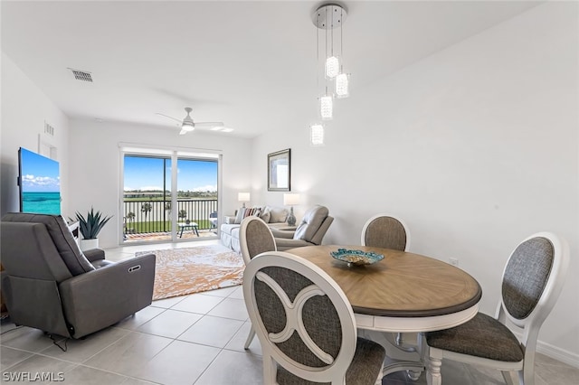 dining space featuring a ceiling fan, visible vents, baseboards, and light tile patterned flooring