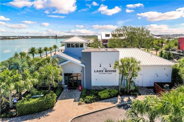 view of front of house featuring metal roof, a standing seam roof, and a water view