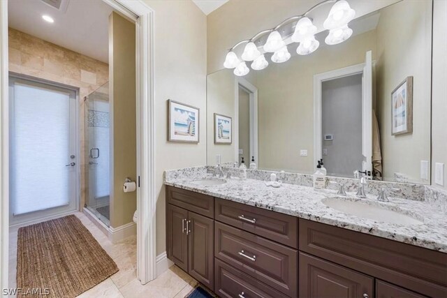 bathroom with toilet, vanity, tile patterned floors, and walk in shower