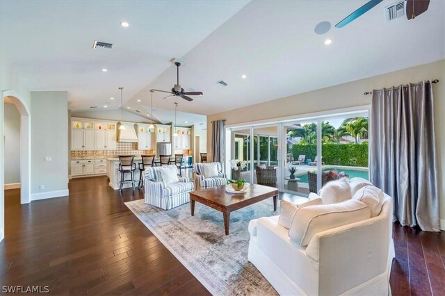 living room with ceiling fan, dark wood-type flooring, and lofted ceiling