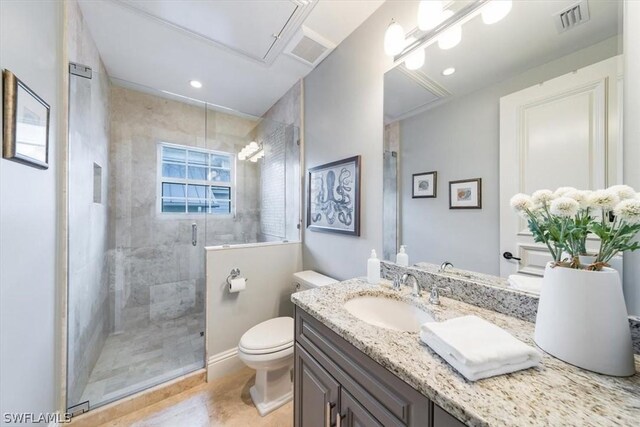 bathroom with vanity, a shower with shower door, and toilet