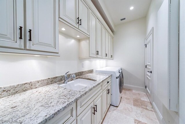 washroom featuring cabinets, separate washer and dryer, and sink