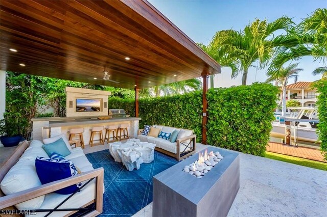 view of patio / terrace with an outdoor living space, a grill, and an outdoor bar