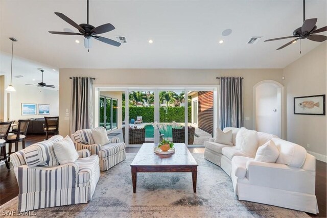 living room with ceiling fan, lofted ceiling, and hardwood / wood-style flooring