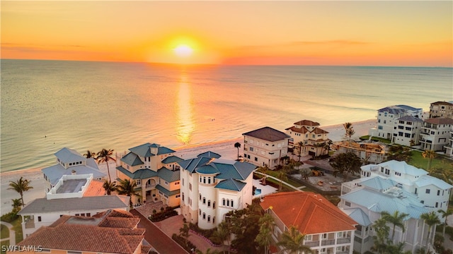 aerial view at dusk featuring a water view