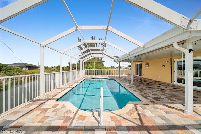 view of swimming pool with glass enclosure and a patio area