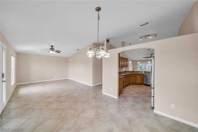 unfurnished living room featuring light tile patterned floors, vaulted ceiling, ceiling fan with notable chandelier, sink, and track lighting