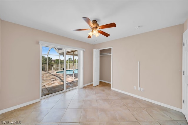 tiled empty room featuring ceiling fan