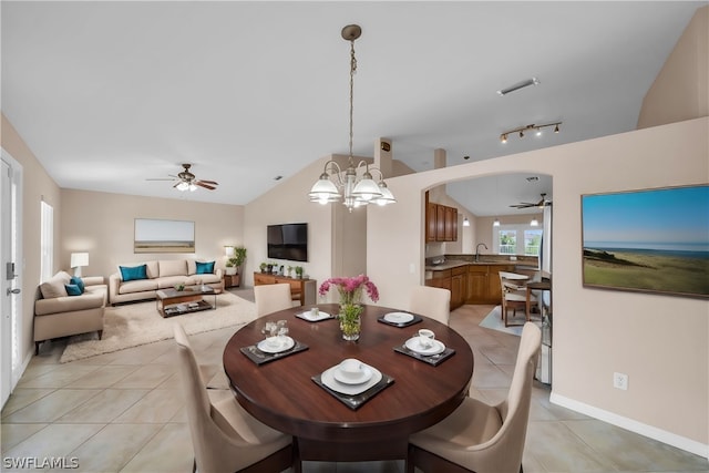 dining area with rail lighting, vaulted ceiling, ceiling fan with notable chandelier, and light tile patterned flooring