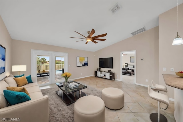 living room featuring lofted ceiling, light tile patterned flooring, and ceiling fan