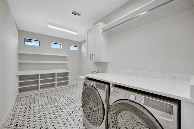 clothes washing area with cabinets and independent washer and dryer