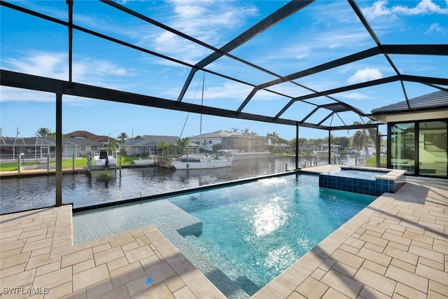 view of pool featuring glass enclosure, a water view, an in ground hot tub, and a patio