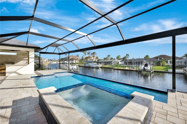 view of pool with an in ground hot tub, a patio, a water view, and glass enclosure