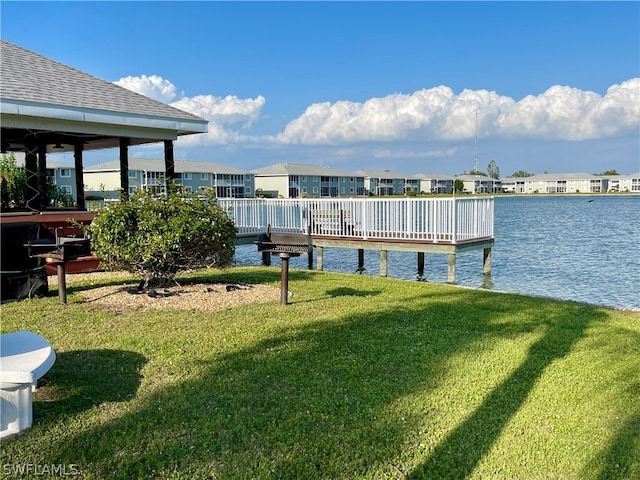 view of dock featuring a water view and a yard