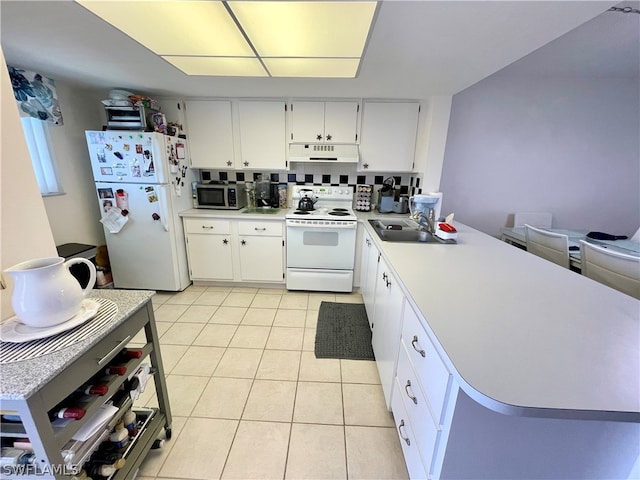 kitchen with light tile patterned flooring, white cabinetry, white appliances, sink, and backsplash