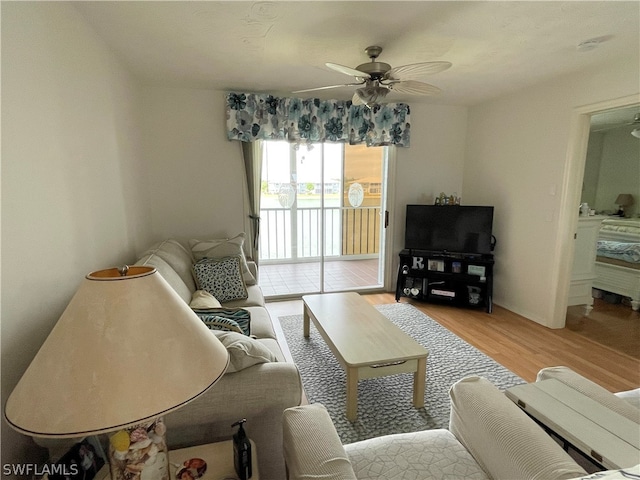 living room with light hardwood / wood-style floors and ceiling fan