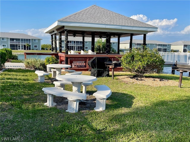 rear view of property with a water view and a lawn