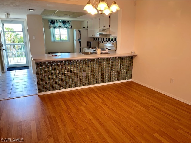 kitchen featuring light hardwood / wood-style floors, white cabinets, decorative light fixtures, and a notable chandelier