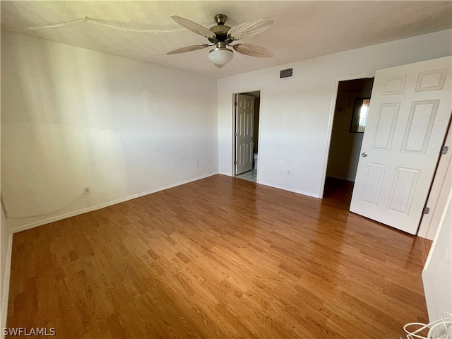 empty room with hardwood / wood-style floors and ceiling fan