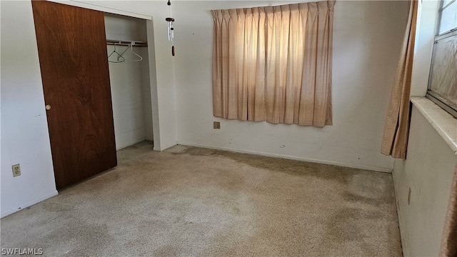 unfurnished bedroom featuring carpet and a closet