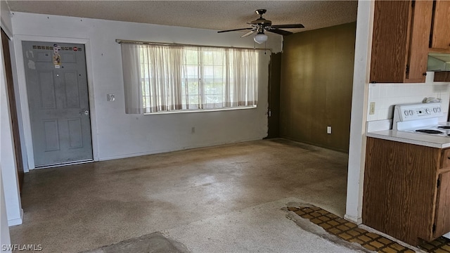 unfurnished dining area featuring ceiling fan and a textured ceiling