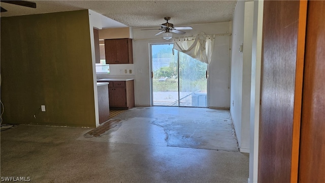 unfurnished living room featuring a textured ceiling and ceiling fan