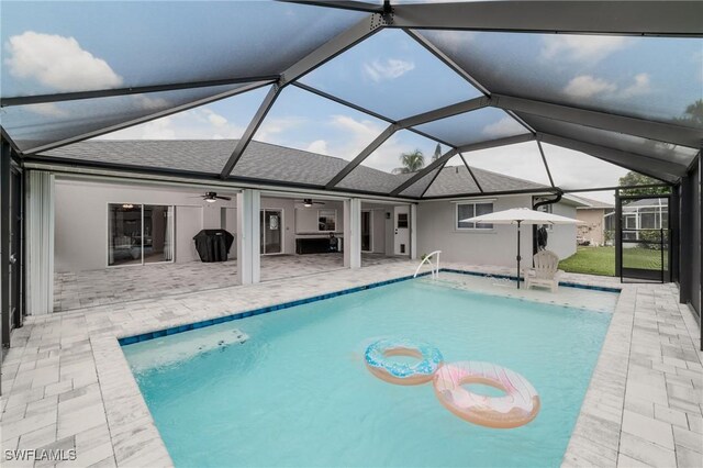 view of pool featuring a patio, ceiling fan, and glass enclosure