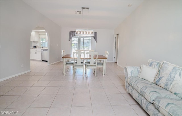 dining space with vaulted ceiling and light tile patterned floors