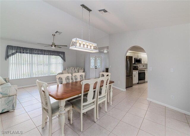 dining space with ceiling fan, lofted ceiling, and light tile patterned floors