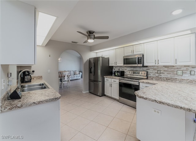 kitchen featuring white cabinetry, ceiling fan, stainless steel appliances, sink, and backsplash