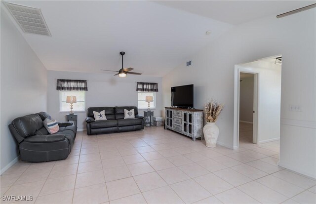 tiled living room with ceiling fan and vaulted ceiling