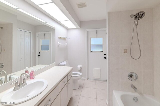 full bathroom with vanity, tiled shower / bath, tile patterned flooring, and toilet