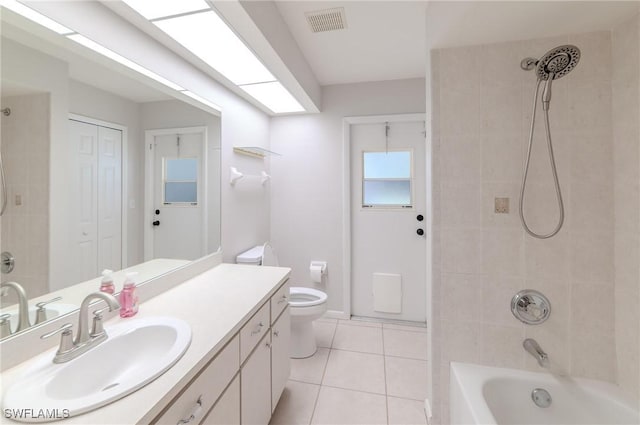 full bathroom with tiled shower / bath, tile patterned floors, toilet, and vanity