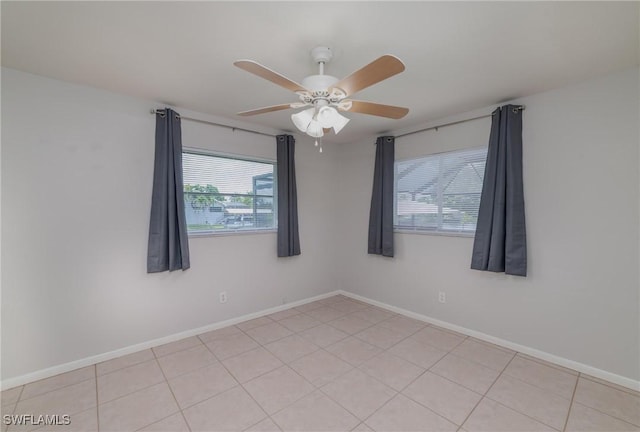 empty room with ceiling fan and light tile patterned flooring