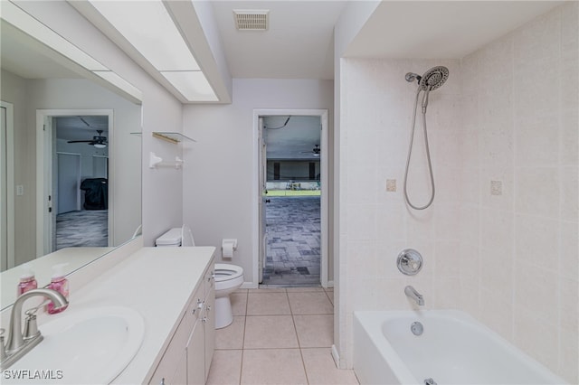 full bathroom with tile patterned flooring, toilet, tiled shower / bath combo, vanity, and ceiling fan