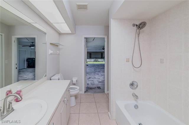 full bathroom featuring ceiling fan, tile patterned flooring, vanity, toilet, and tiled shower / bath