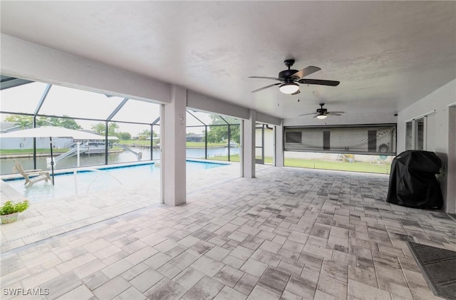 view of swimming pool featuring a patio, a water view, a grill, and ceiling fan