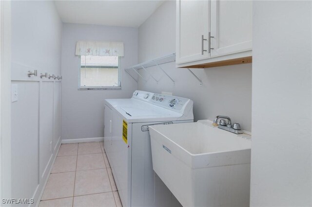 washroom featuring sink, cabinets, washer and dryer, and light tile patterned floors